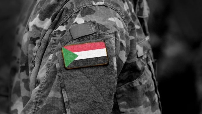 Flag of Sudan on soldiers arm. Sudan flag on military uniform. Army, troops, Africa (collage).