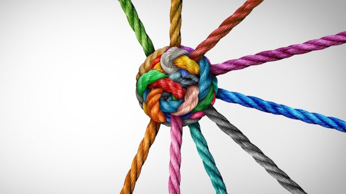 Collective Effort Integration and Unity with teamwork concept as a business metaphor for joining a partnership synergy and cohesion as diverse ropes connected together in interdependence.