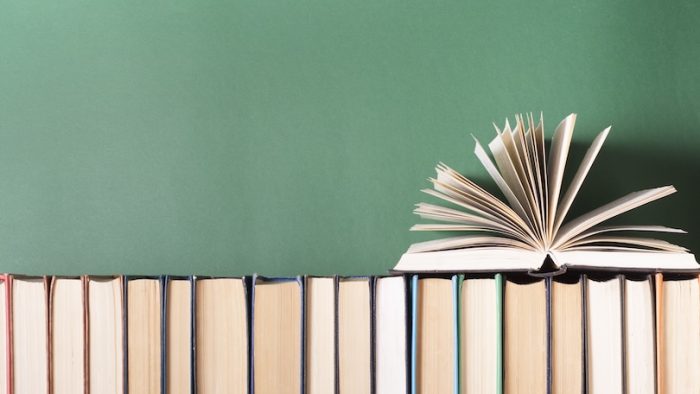 Open book, hardback books on wooden table. Education background. Back to school. Copy space for text.