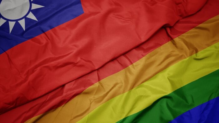 waving colorful gay rainbow flag and national flag of taiwan. macro