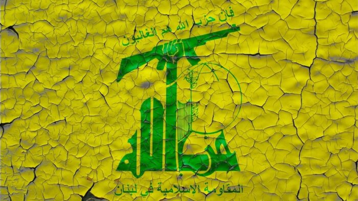 Hezbollah flags painted over cracked concrete wall