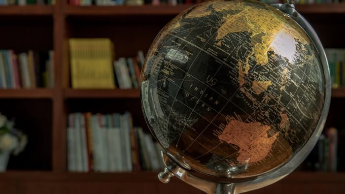 Chiang Rai,Thailand - Sep 06, 2020 : Replica globe on the background of bookshelves in library with copy space. No focus, specifically.