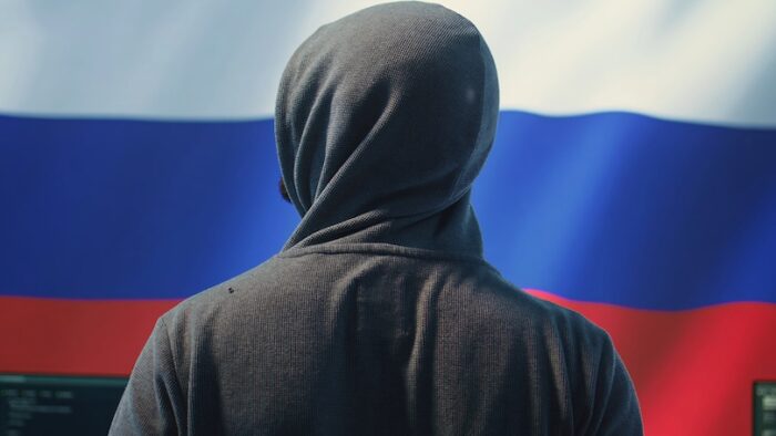 Expert in governmental hacking room with a Russian flag on big screen, individual in cyberwarfare and propaganda. Russian federation hacker works on sabotage and political manipulation. Camera B.
