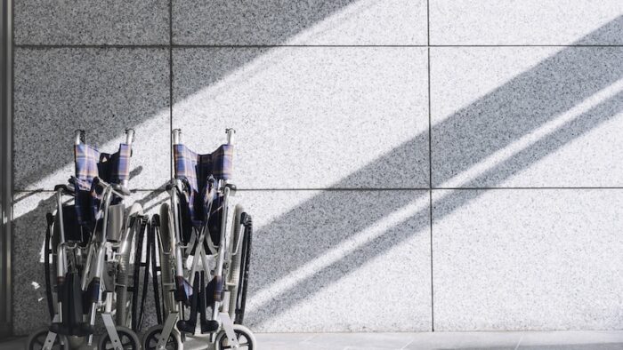 Empty Wheelchair on wall Background with shadow lighting