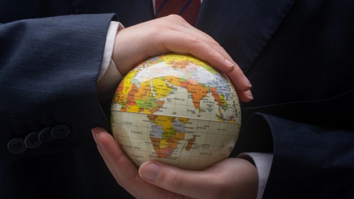 Businessman is standing with an earth globe fot business concept