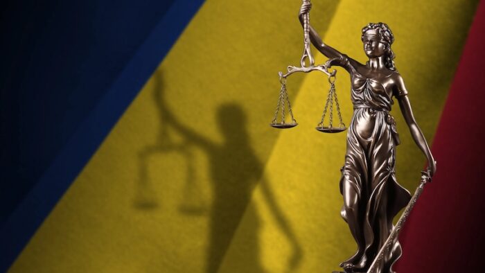 Romania flag with statue of lady justice and judicial scales in dark room. Concept of judgement and punishment, background for jury topics