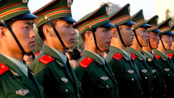 Beijing, China - May 1, 2005:  A row of somber Chinese soldiers watch the evening flag-lowering ceremony in Tiananmen Square