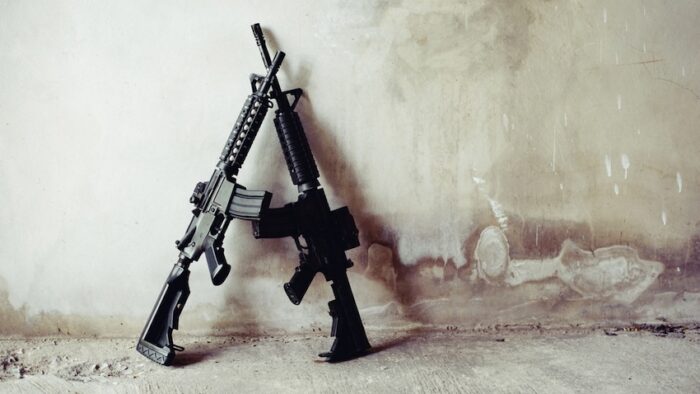 Rifle guns on grunge wall in abandoned house. Terrorist and Soldier concept. Robber and Police concept. War machine gun theme.