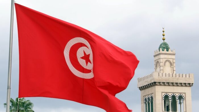 Red flag, clouds and minaret in Tunisia