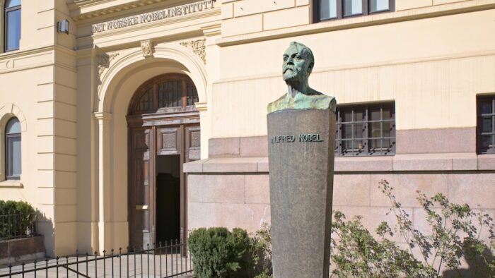 Entrance of The Norwegian Nobel Institute in Oslo with a bust of Alfred Nobel in the foreground.