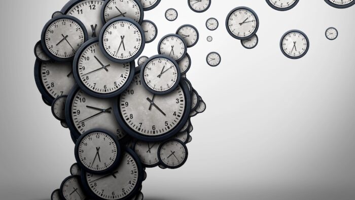 Planning time business concept or wasting minutes as a group of timepieces or clocks shaped as a human head as a health symbol for psychology or scheduling pressure and dementia or loss and aging as a 3D illustration.