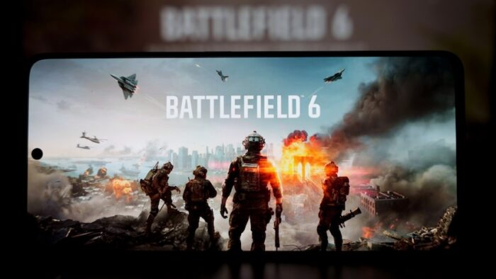 Screen showing Battlefield 6 video game scene with soldiers, jets, and explosions. High quality photo